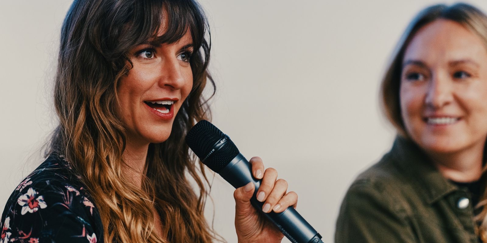 Beatrice Aretz speaking into a microphone during an interview.